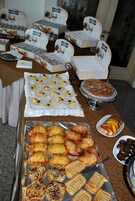 Ein reichhaltiges Buffet mit verschiedenen Backwaren, darunter Gebäck, Muffins und eine Torte.