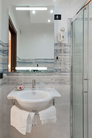Tweepersoonskamer, uitzicht op zee | Badkamer | Een douche, een haardroger, badjassen, pantoffels