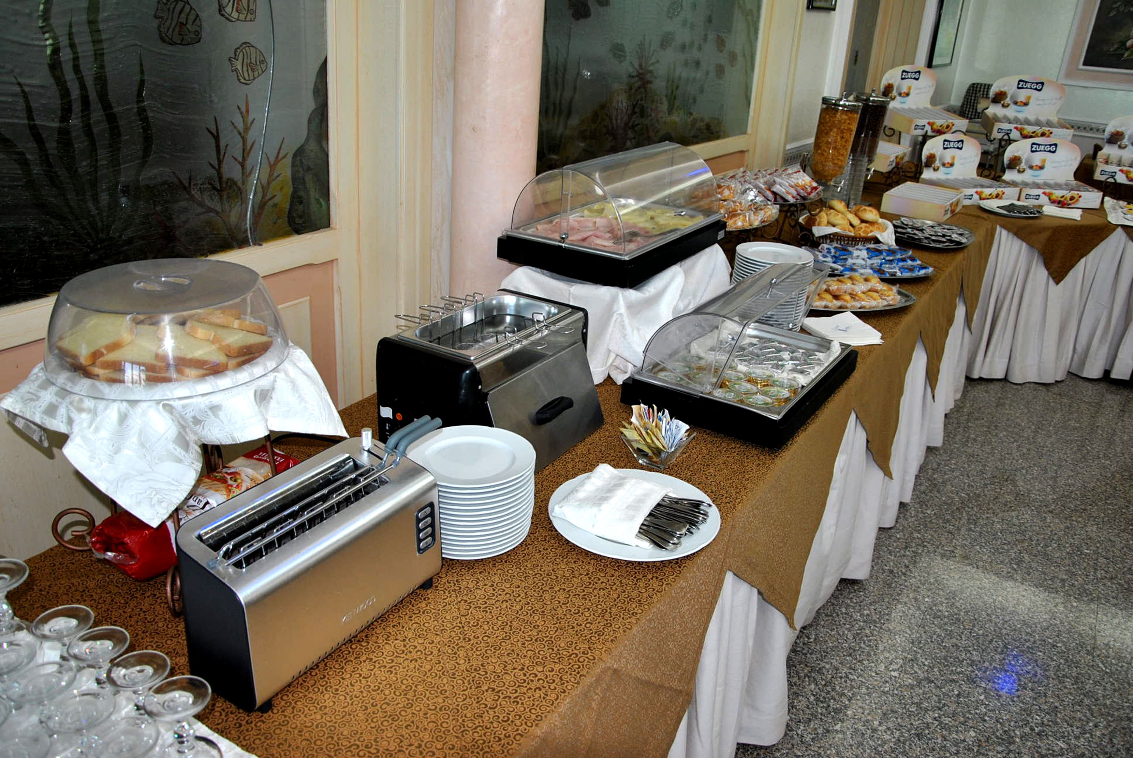 Una mesa de buffet con diversos alimentos y un tostador.