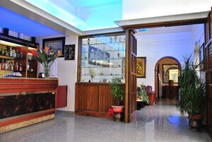 A lobby with a reception desk, a glass display case with decorative items, and a potted plant.