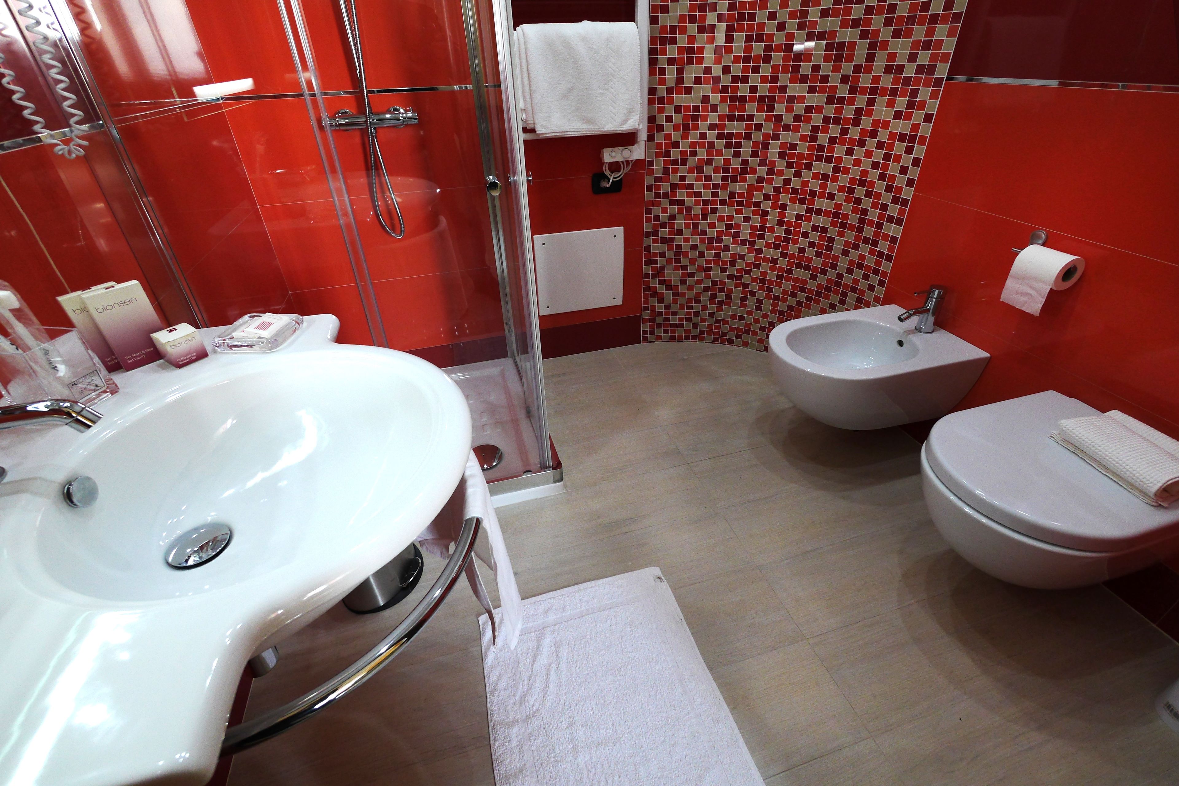 A bathroom with a white sink, a bidet, and a toilet.