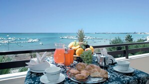 Een tafel met ontbijtartikelen en een prachtig uitzicht op zee.