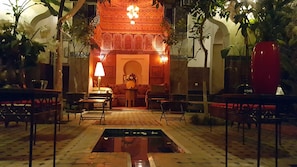 A traditional interior with a central fountain, seating areas, and ornate decor. - Riad Jenaï Demeures du Maroc (Marrakech)