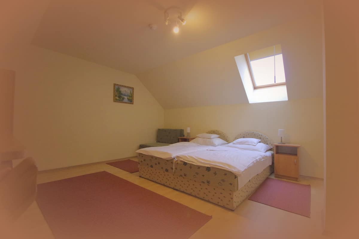 Un dormitorio con una cama, una mesita de noche, una ventana y un cuadro en la pared.