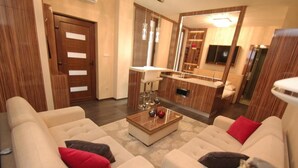 A modern living room with a sofa set, a coffee table, and a mirror reflecting the room. - Hotel Vadászkürt Superior (Szekesfehervar)