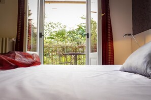Doppia Basic, bagno condiviso | Copriletto in piuma, minibar, una scrivania, tende oscuranti