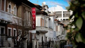 A hotel with a prominent 'HOTEL' sign, classic architecture, and a stone facade. - Hotel RossoVino (Milan)