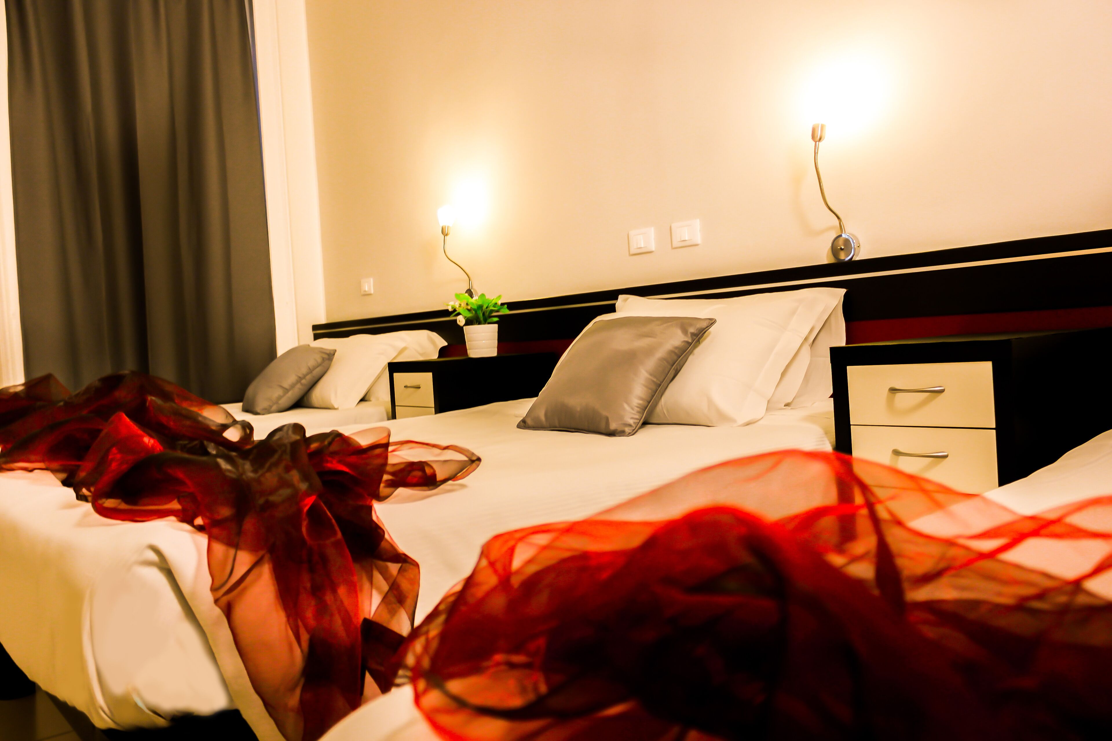 Een hotelkamer met een bed, nachtkastjes en een nachtkastje met een lamp.
