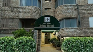 A stone building with a sign reading "The new Eden Hotel." - Eden Hotel (Haifa)