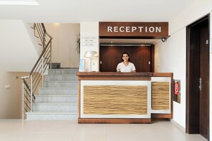 A reception desk with a sign, a staircase, and a door. - Ammos Bay (Parga)