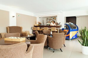 A hotel lobby with striped armchairs, a bar area, and a vending machine. - Ammos Bay (Parga)