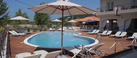 Piscine extérieure, parasols de plage, chaises longues