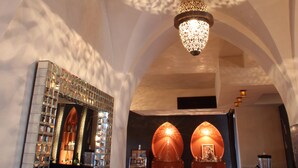 Un intérieur agrémenté d’un lustre, d’un miroir et d’un coin bar.