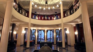 Un vaste hall d’entrée avec une fontaine centrale, de nombreux espaces de détente et un balcon offrant une vue panoramique.