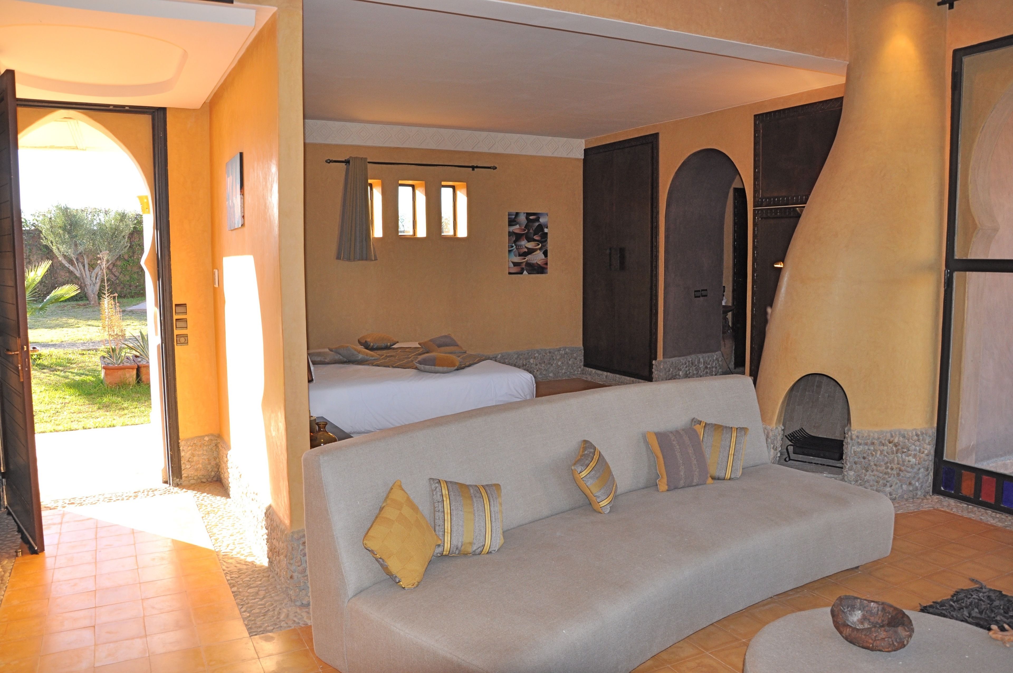 A cozy room with a sofa, a bed, and a fireplace.