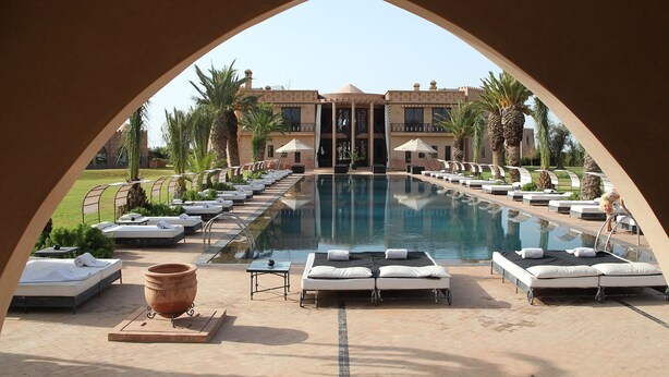 Un espace aménagé au bord de la piscine, avec des chaises longues et une grande piscine.