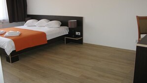 Una habitación de hotel con una cama, una mesita de noche y una lámpara.