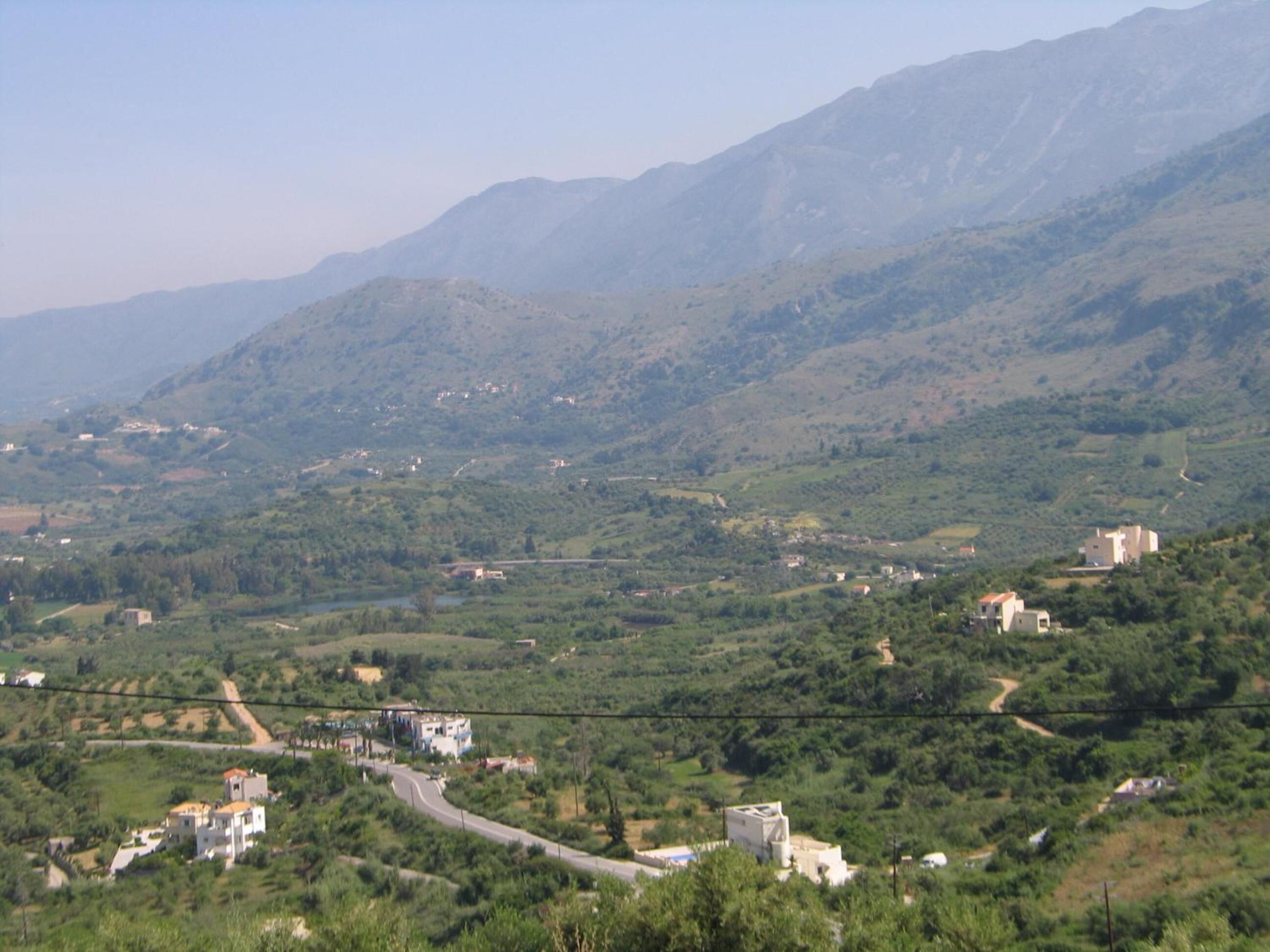 A mountainous landscape with scattered buildings and a winding road.