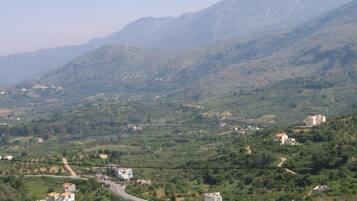 A mountainous landscape with scattered buildings and a winding road.