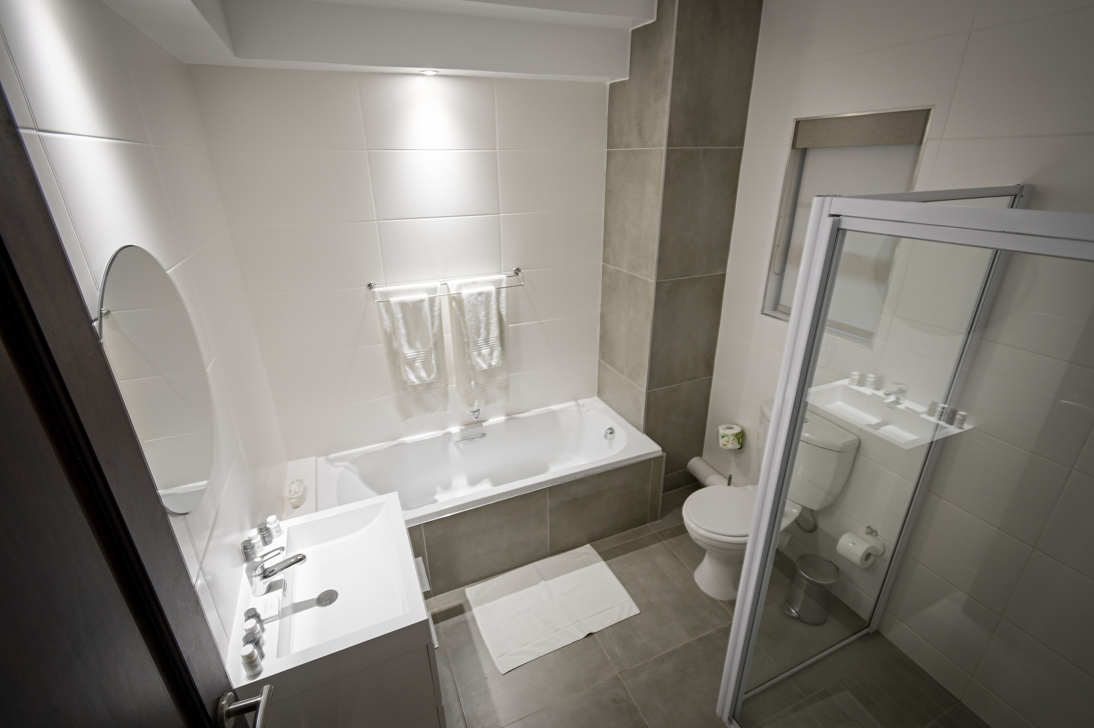 Ein modernes Badezimmer mit Badewanne, Toilette und einer Duschkabine.