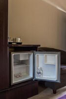 A small, dark wooden cabinet with a microwave on top.