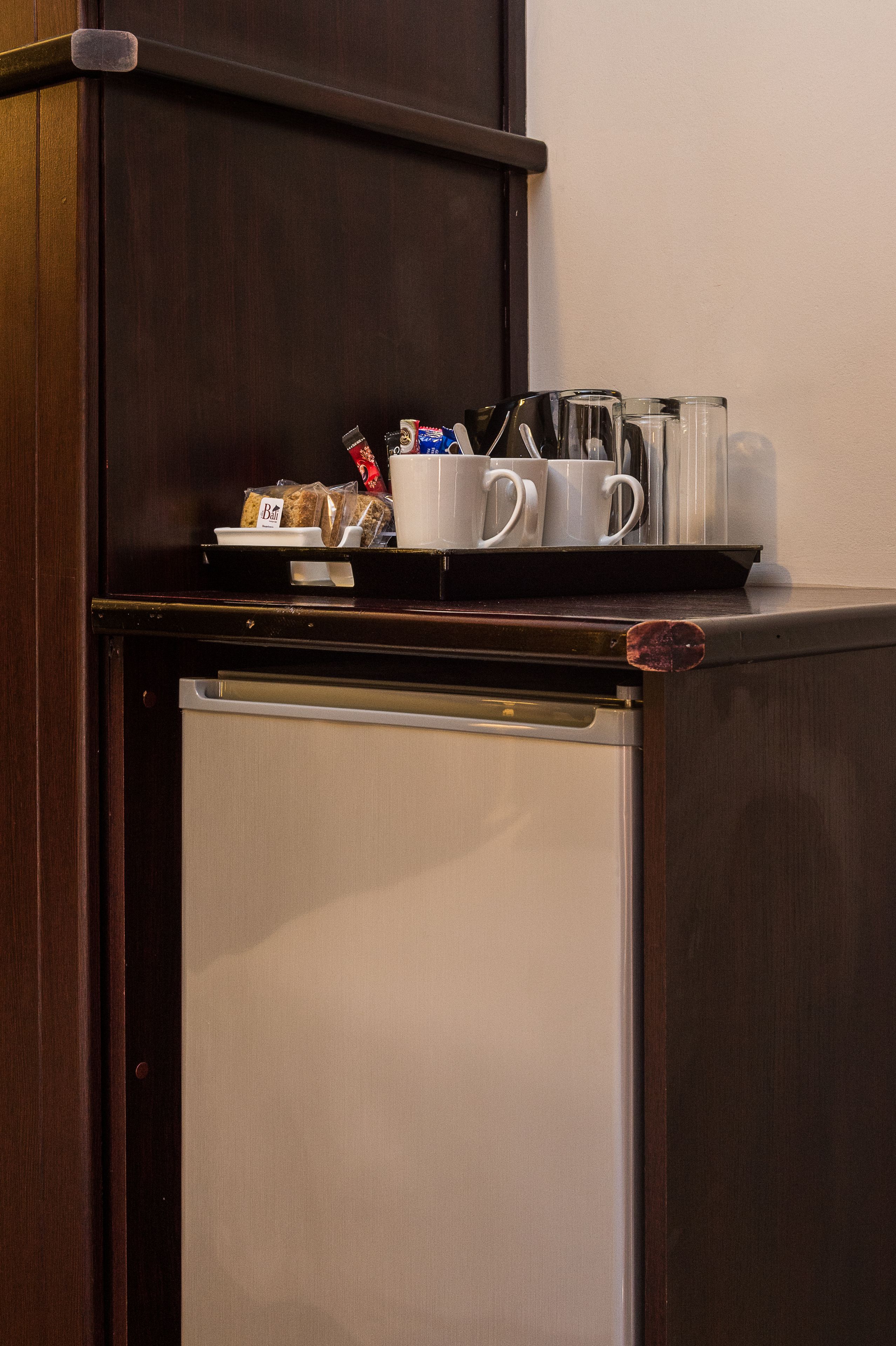 Une petite cuisine équipée comprenant un réfrigérateur, un four à micro-ondes et un petit plan de travail.
