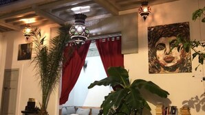 A cozy indoor seating area with a round table, chairs, and a potted plant. - Riad Dar Nabila (Marrakech)