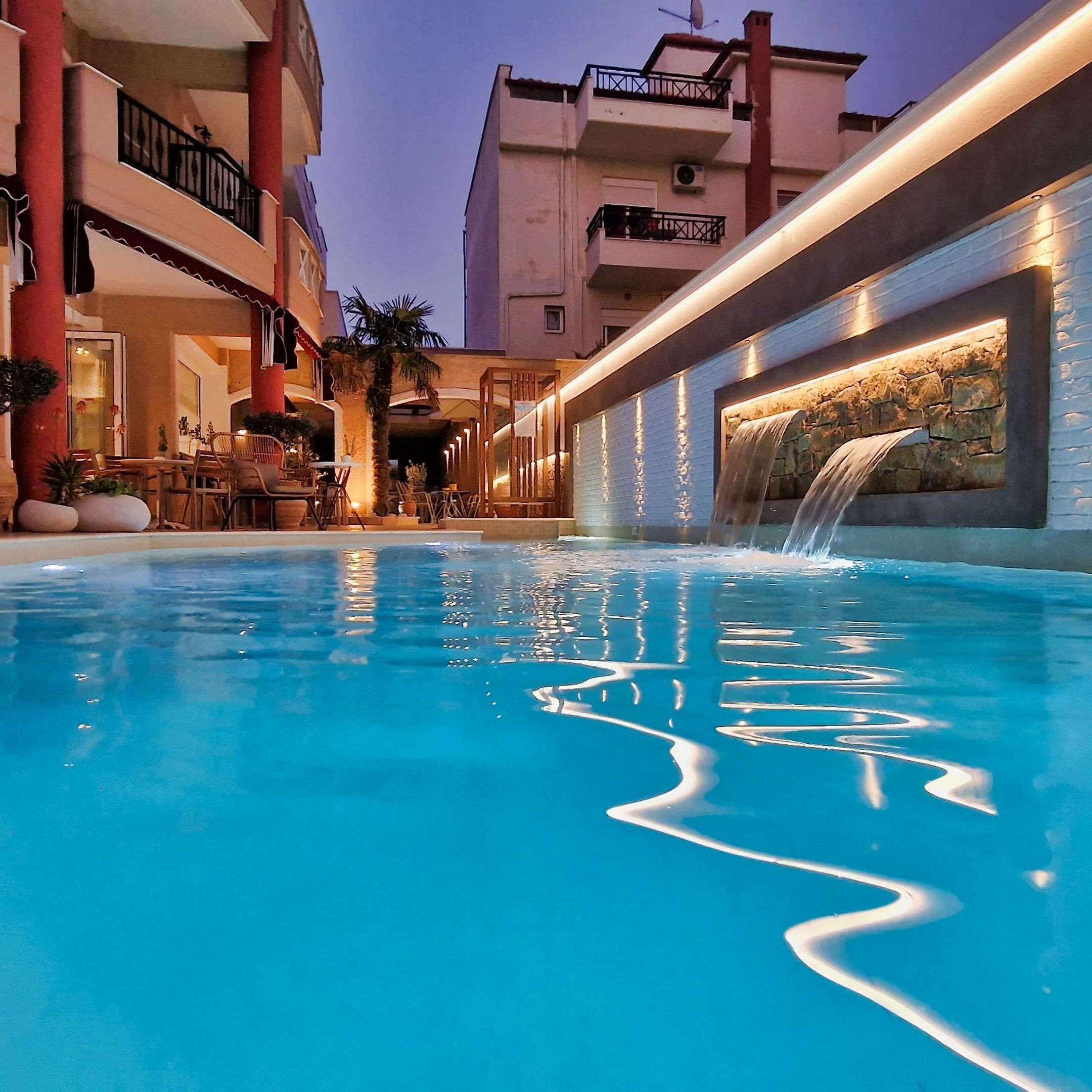Una piscina al aire libre, sombrillas, sillones reclinables de piscina