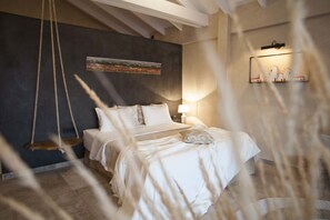 A bedroom with a bed, a hanging swing, a painting on the wall, and a shelf with decorative items. - Evilion Sea And Sun (Dio-Olympos)