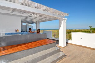 Una piscina al aire libre, sombrillas, sillones reclinables de piscina