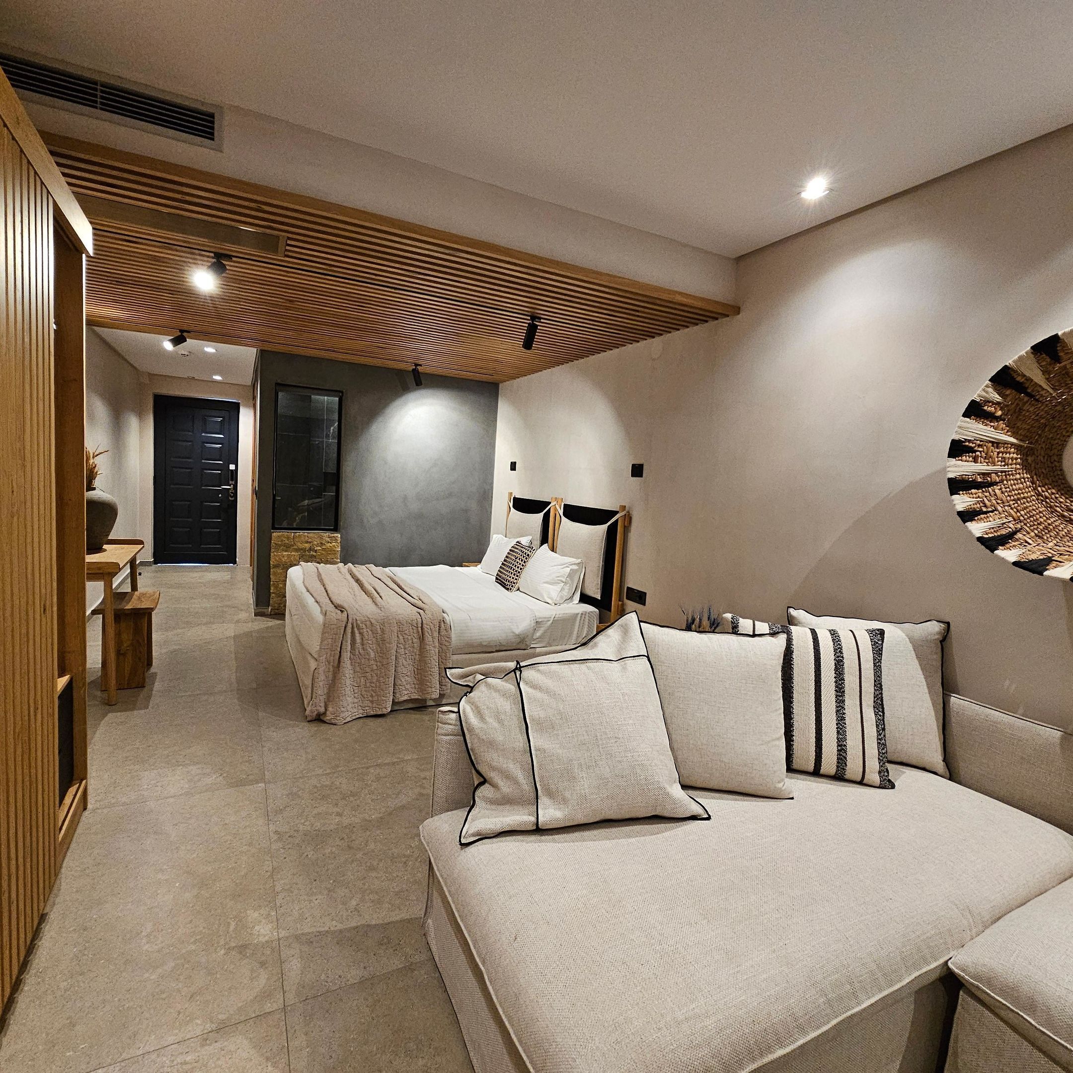 Une chambre moderne avec deux lits, un plafond en bois et une grande œuvre d’art murale.