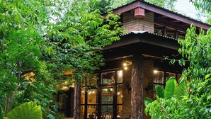 A wooden pathway leading to a building surrounded by lush greenery. - La Aldea de la Selva Lodge (Puerto Iguazú)