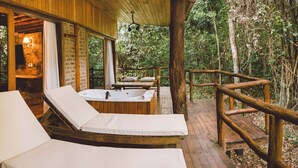 A wooden deck with two sun loungers and a hot tub. - La Aldea de la Selva Lodge (Puerto Iguazú)