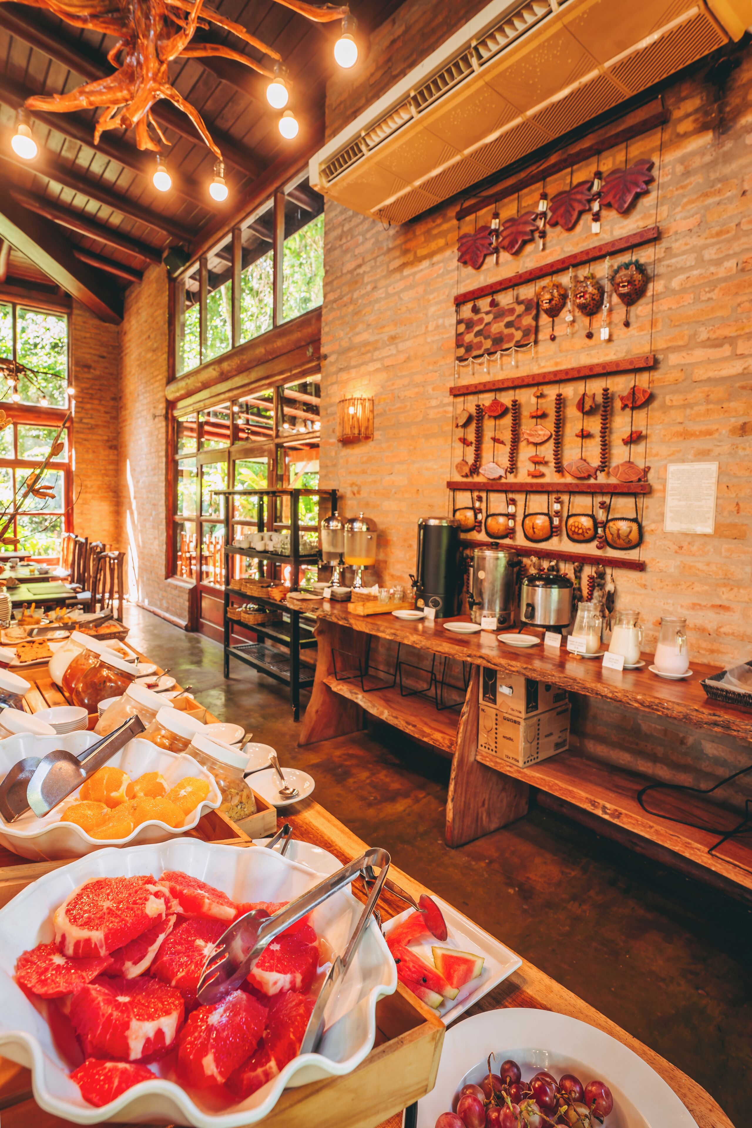 A buffet area with various food items and a rustic brick wall with hanging decorations.
