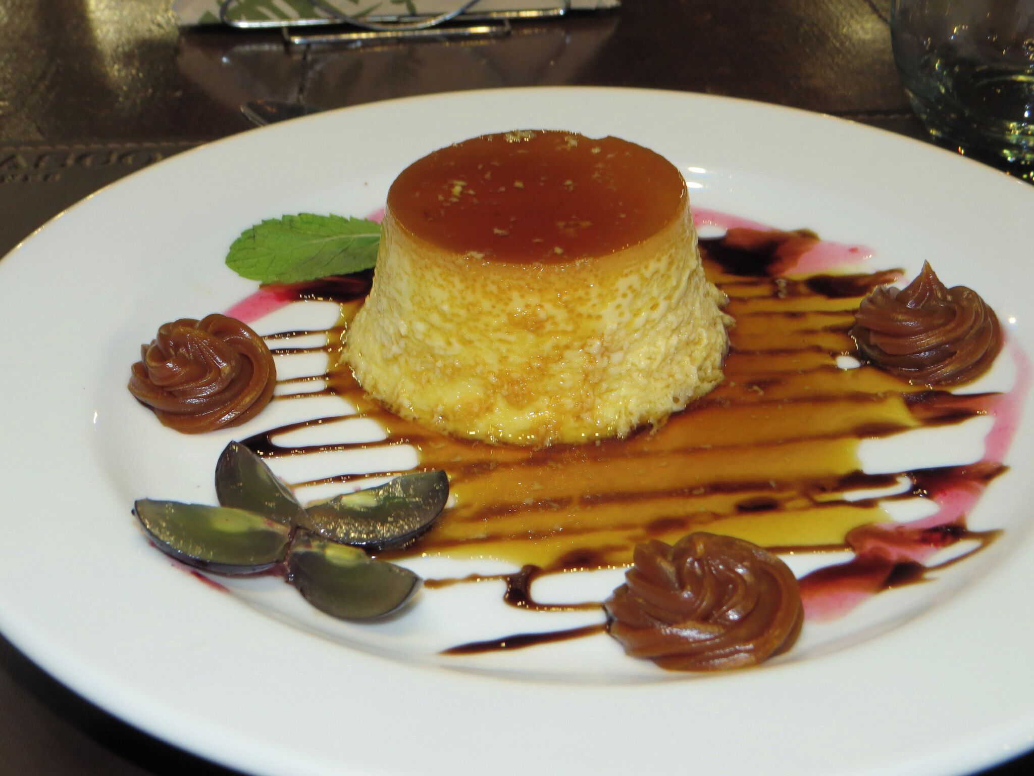 Un postre en un plato con salsa de caramelo y decoraciones de chocolate.