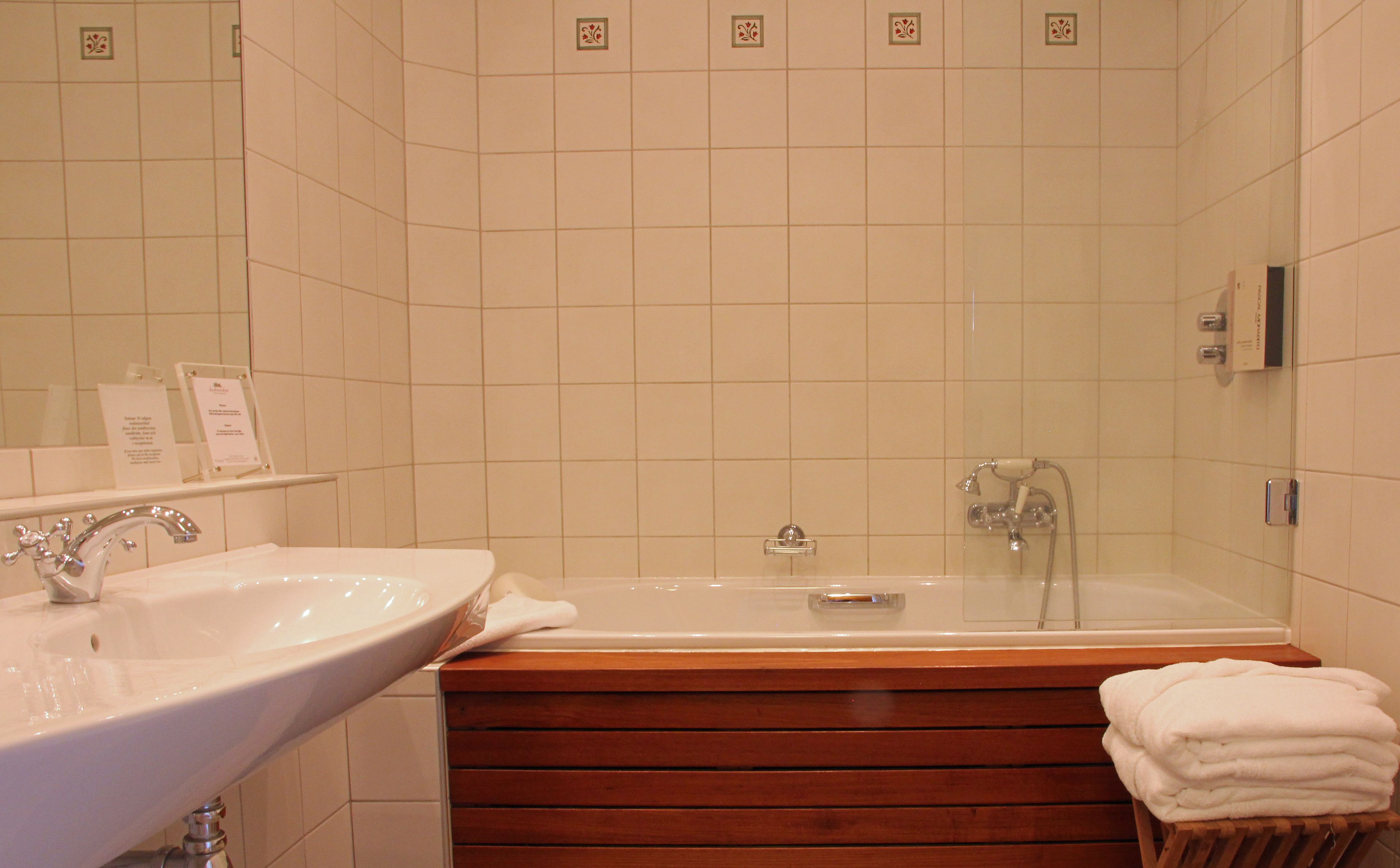 Ein Badezimmer mit Waschbecken, Spiegel und Badewanne.