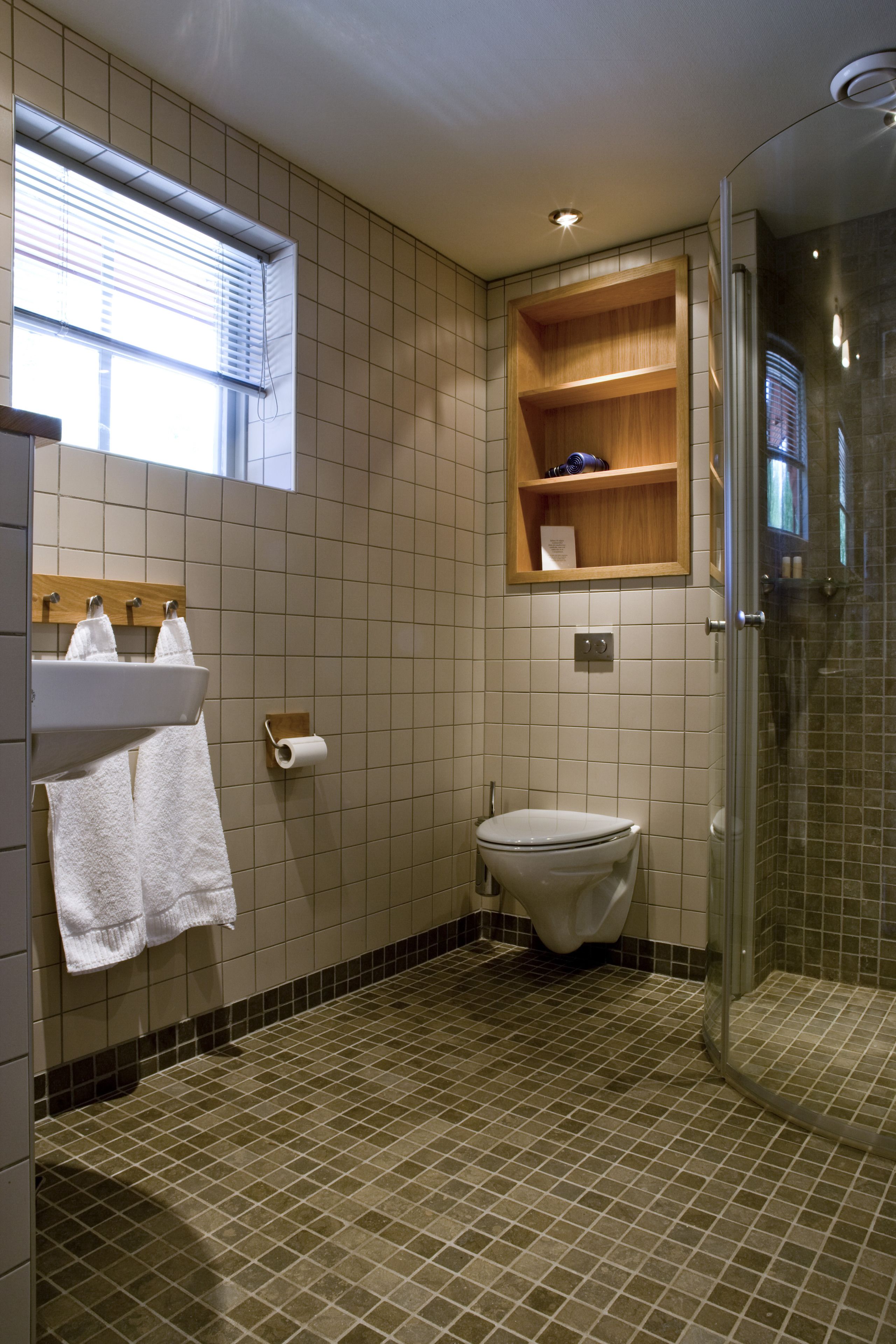 A bathroom with a toilet, sink, and shower.