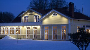 Een gebouw met twee verdiepingen, met een bord waarop 