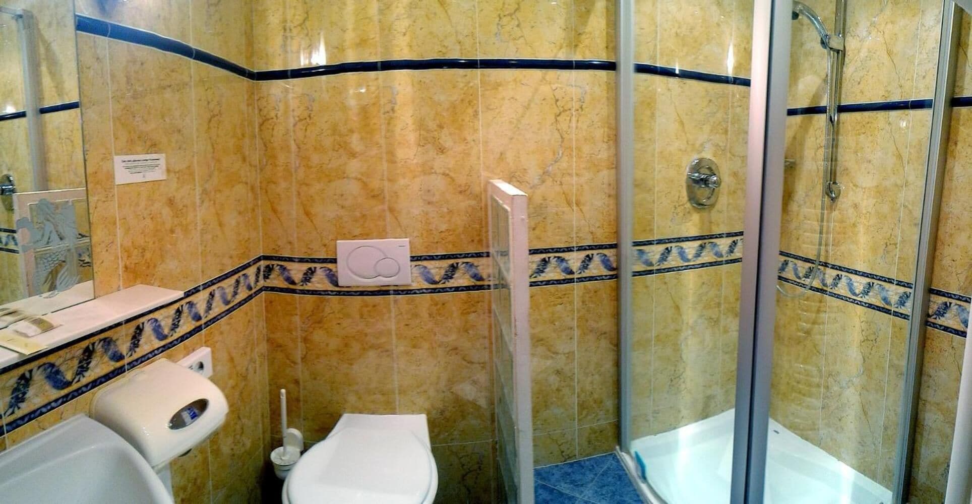 A bathroom with a toilet, bidet, and shower stall.