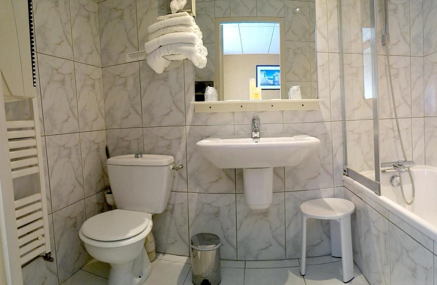 A bathroom with a toilet, sink, and bathtub.