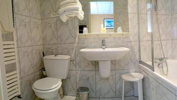 A bathroom with a toilet, sink, and bathtub.