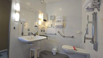 Un baño moderno con lavamanos, inodoro y ducha.