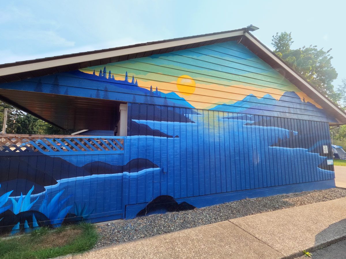 A building with a mural of a mountain landscape on its side.