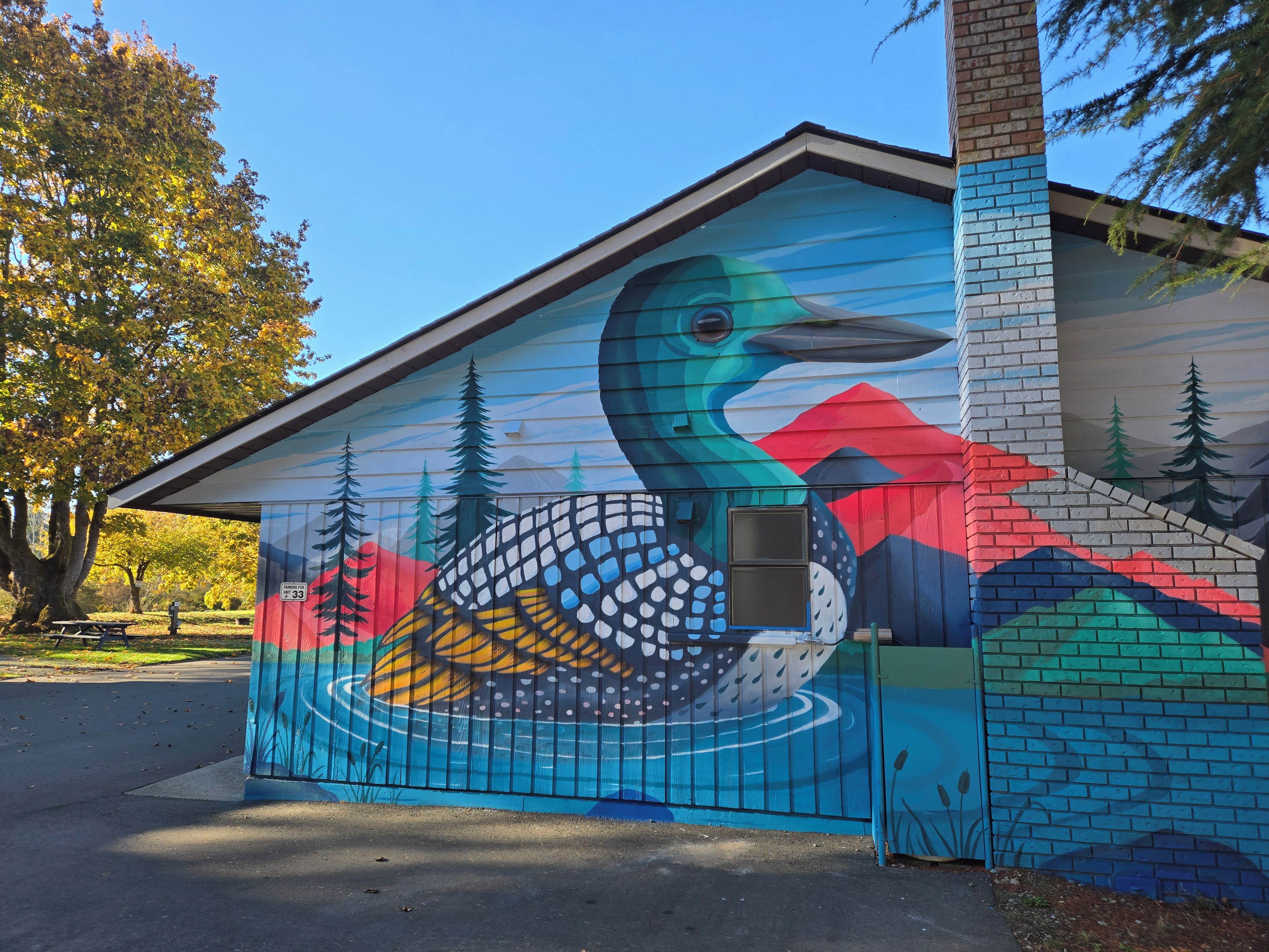 A building with a colorful mural of a bird and mountains.