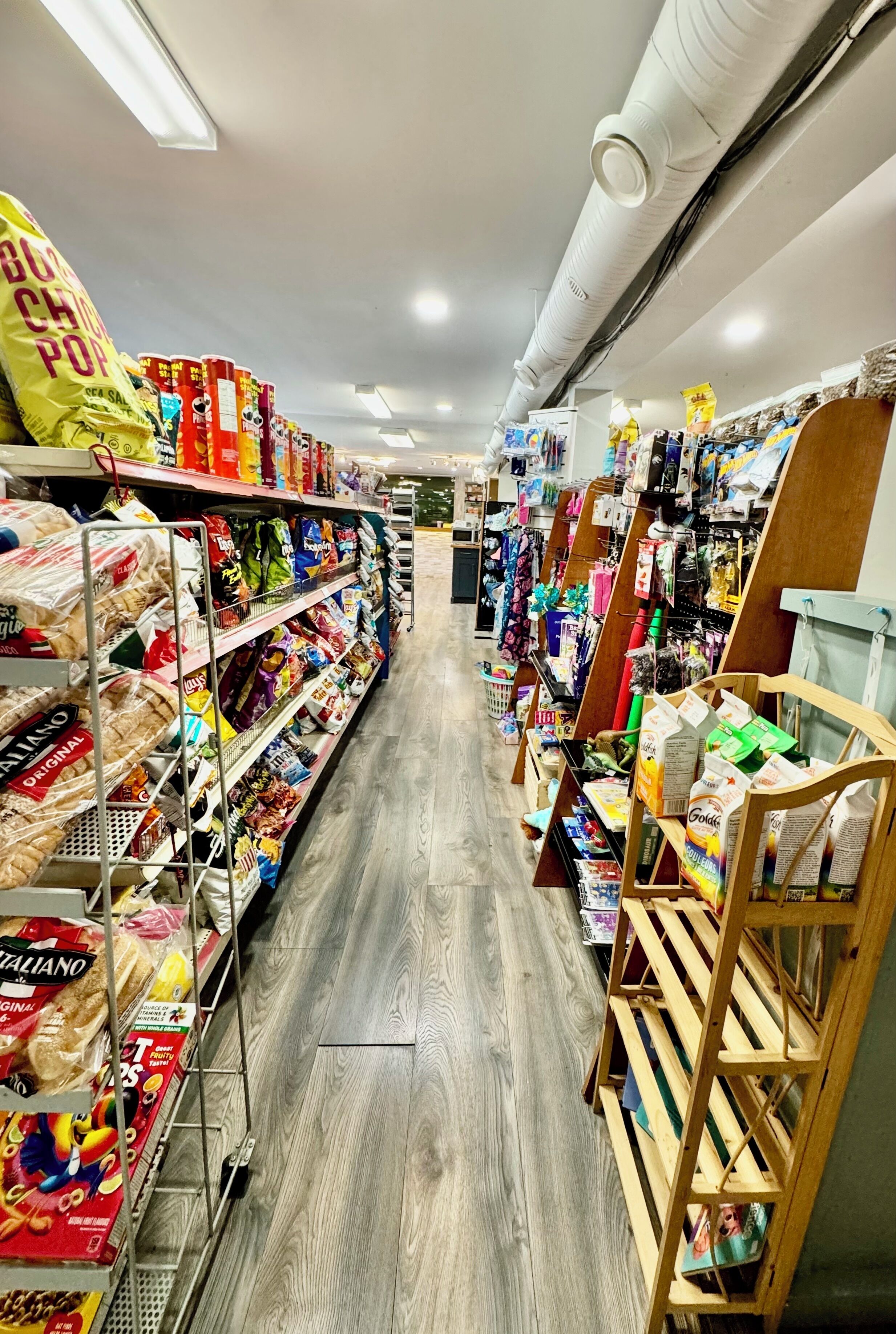 Un pasillo de un supermercado con estantes llenos de diversos productos alimenticios y artículos para el hogar.