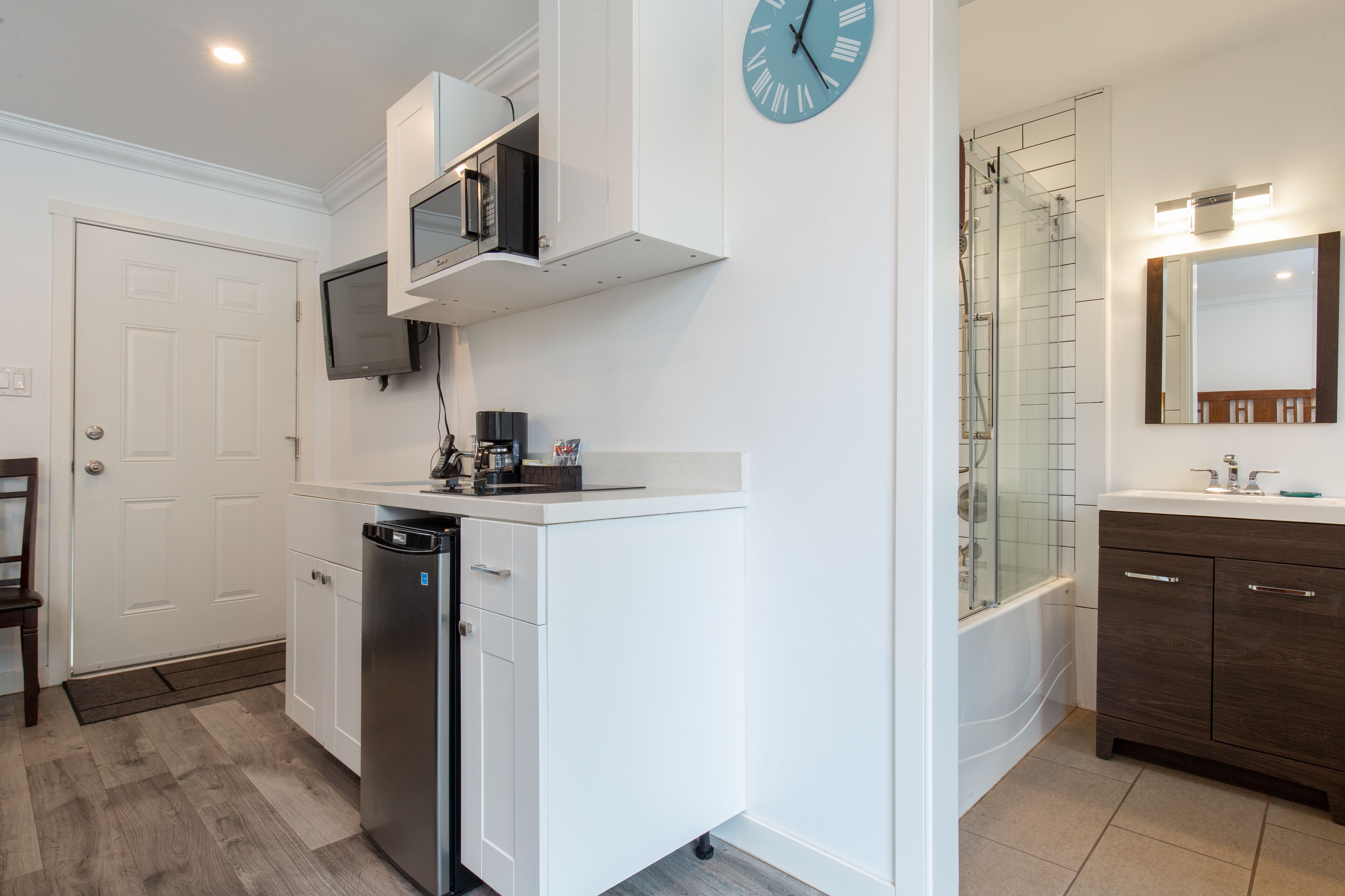 A modern kitchen with white cabinetry, a built-in microwave, and a dishwasher.