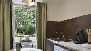 A compact kitchen with a window, a coffee maker, and a sink. - Le Manoir de la Giraudière (Beaumont-en-Veron)
