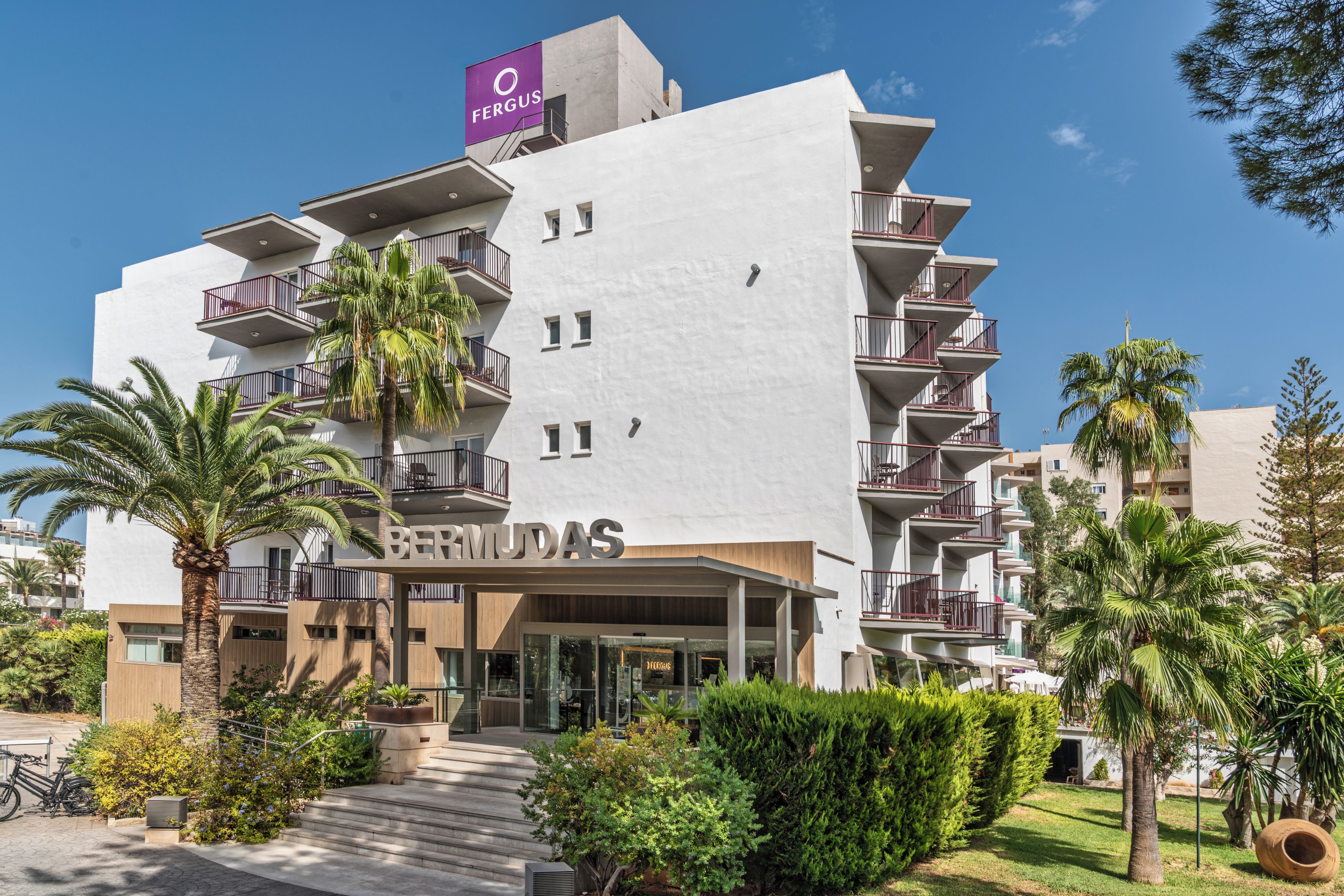 Un hôtel à plusieurs étages doté de balcons, une enseigne indiquant « BERMUDA » et une autre, plus petite, au-dessus, portant le nom « FERGUS ».