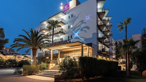 A modern hotel with multiple balconies, palm trees, and a prominent 'O FERGUS' sign. - FERGUS Bermudas (Calvia)
