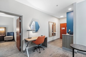 A modern office space with a desk, office chair, and a reception desk.